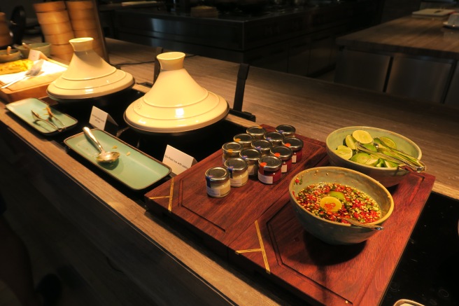 a table with bowls of food and sauces