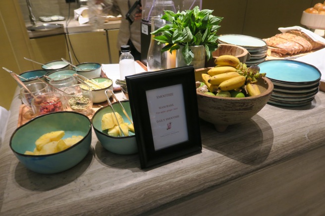 a table with bowls of fruit and a frame