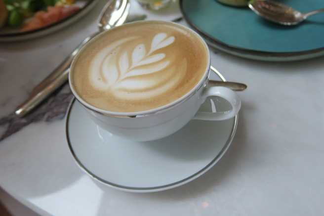 a cup of coffee with a leaf design on top