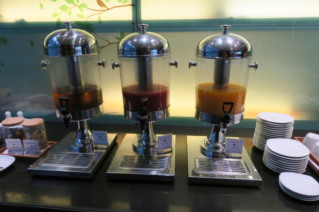 a group of juice dispensers on a table