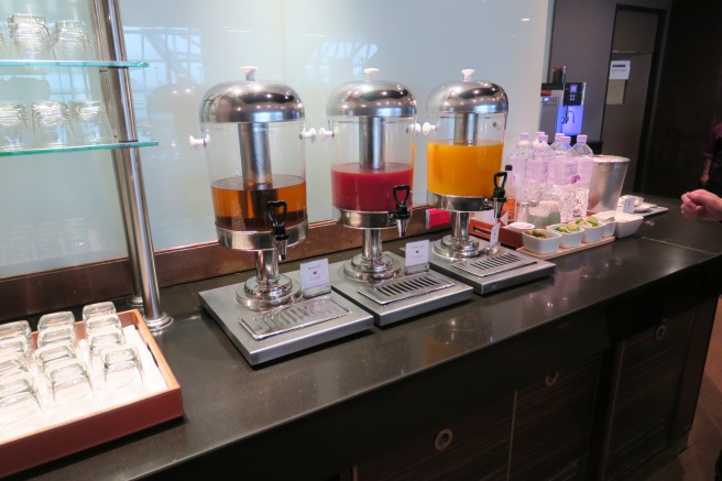 a group of juice dispensers on a counter