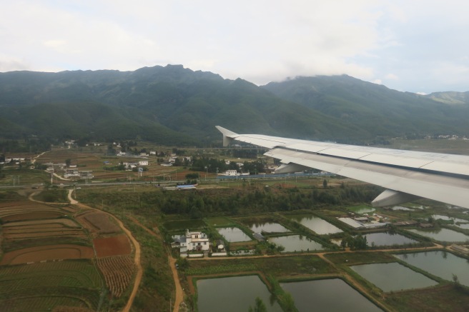 an airplane wing over a landscape