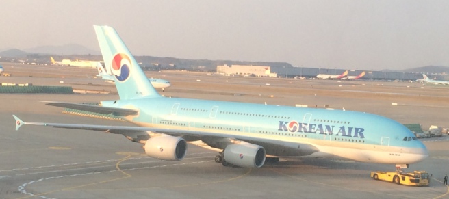 a blue airplane on a runway