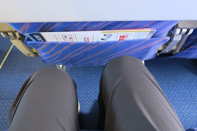 a person's legs and a pocket on a seat