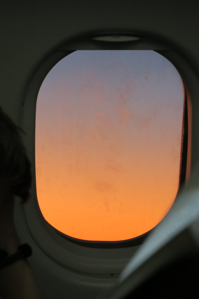 a window with a sunset in the background