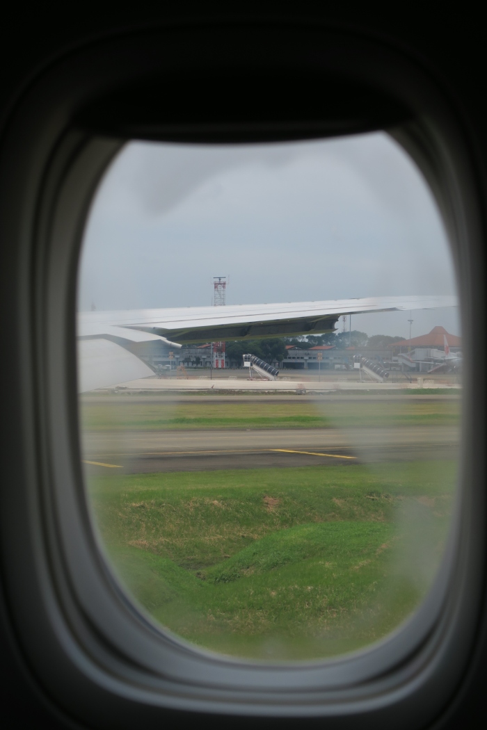 an airplane window with a wing on the ground