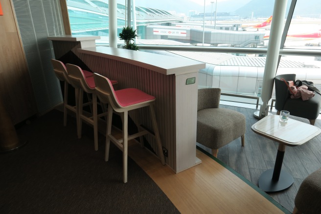 a bar with chairs and a table in front of a window