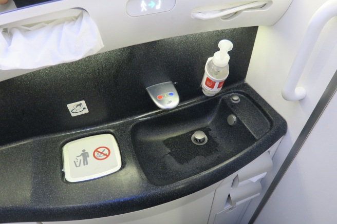 a sink with a soap bottle and a bottle of liquid on it