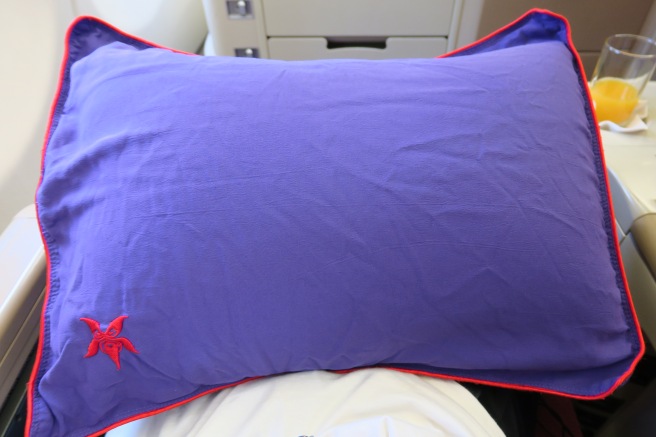 a purple pillow with red trim