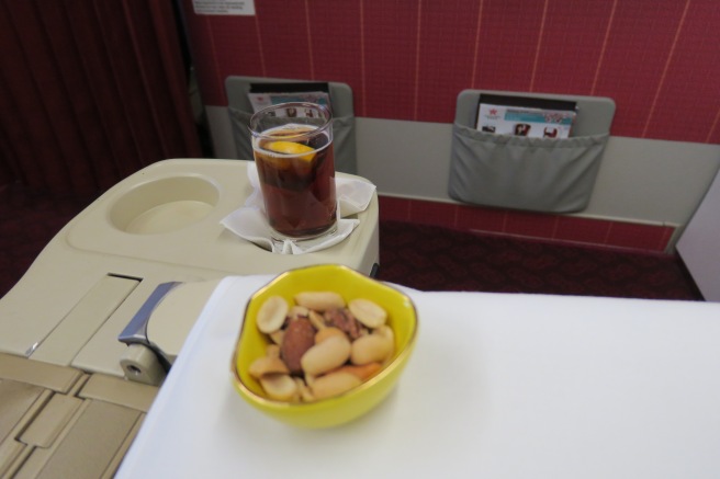 a bowl of nuts and a drink on a table