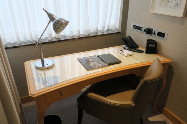 a desk with a lamp and a telephone