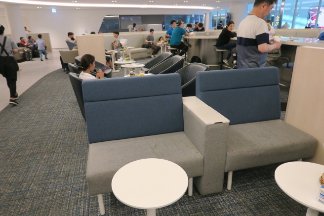 a group of people sitting in a room with chairs and tables