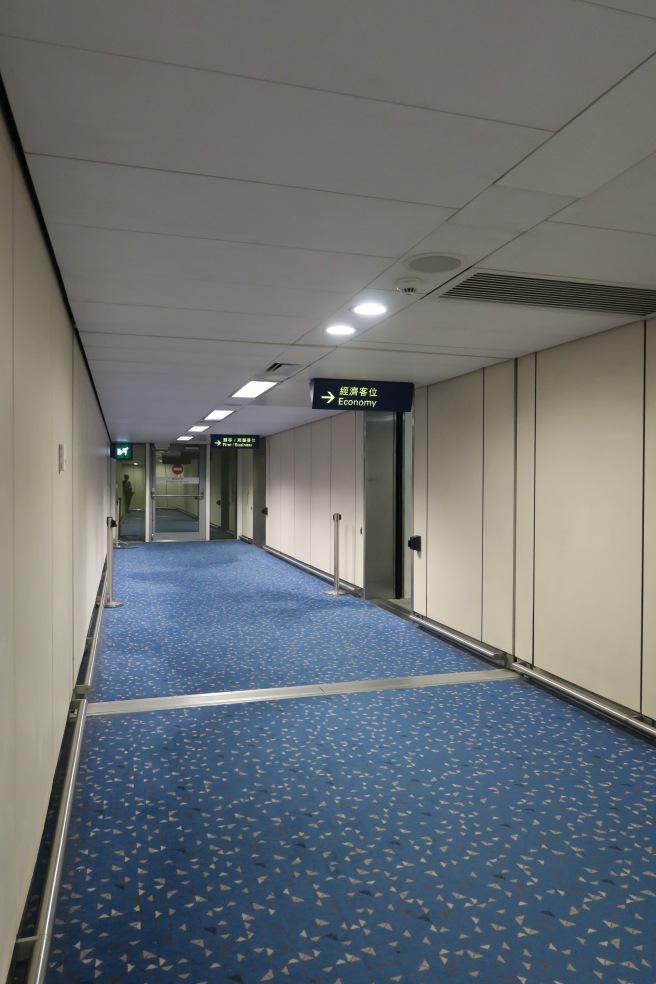 a hallway with blue carpet and a sign