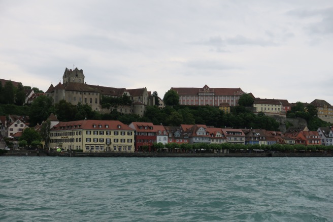 a group of buildings on a hill by water