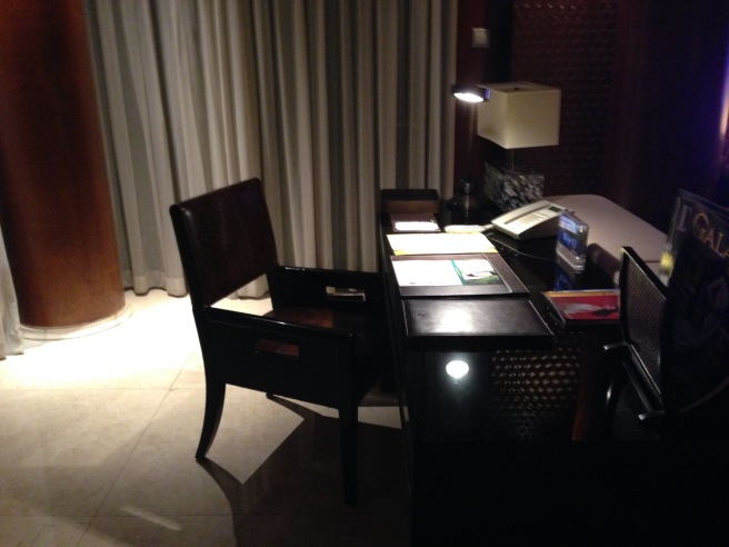 a desk with a lamp and a chair