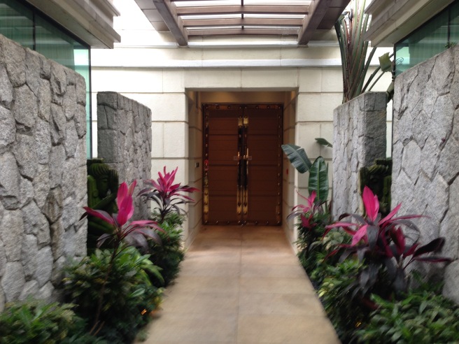 a hallway with plants and a door