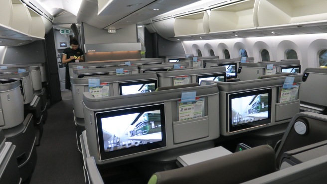 a row of seats with monitors on the side