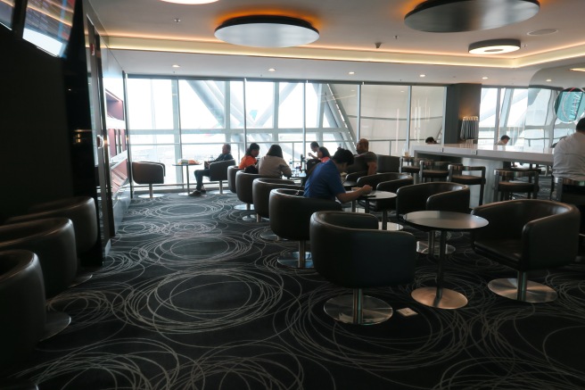 people sitting in a room with tables and chairs