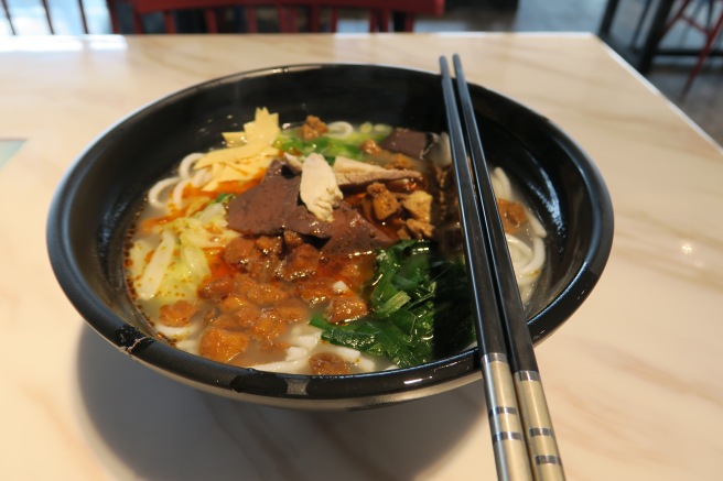 a bowl of soup with chopsticks