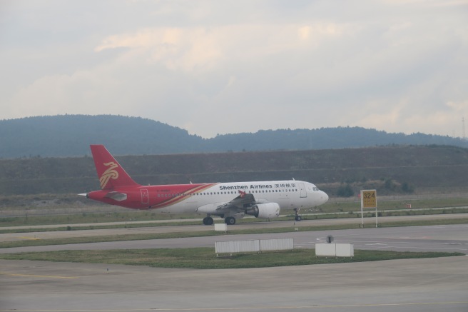 a red and white airplane on a runway