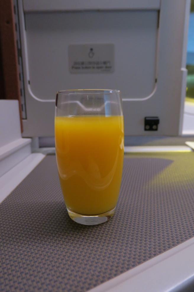 a glass of orange juice on a table