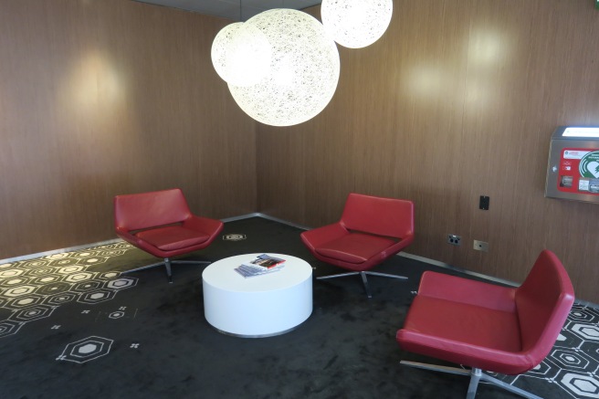 a room with red chairs and a white table