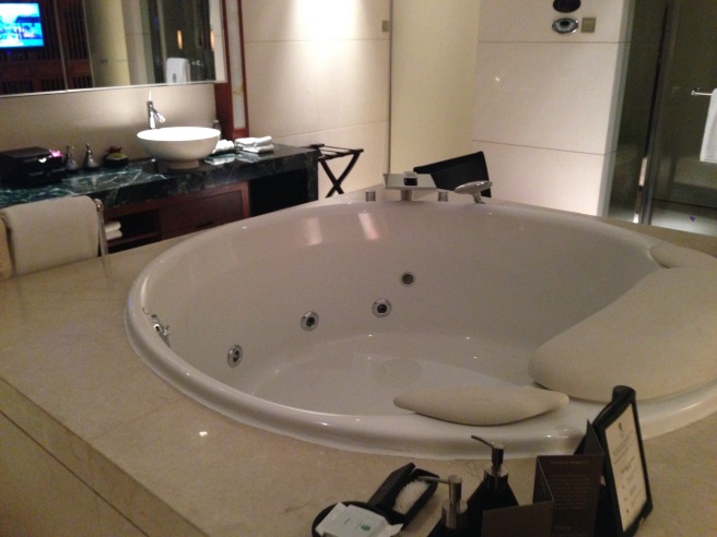 a large white bathtub in a bathroom