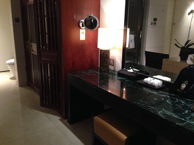 a black marble counter top with a lamp and a mirror