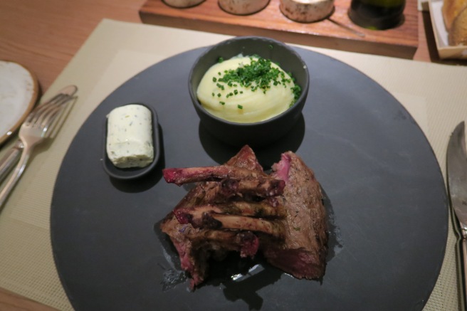 a plate of food with a bowl of mashed potatoes and a knife