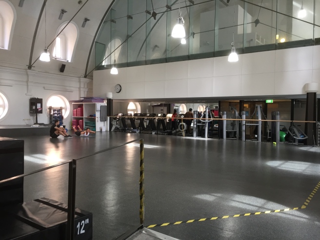 people sitting on a black floor in a gym