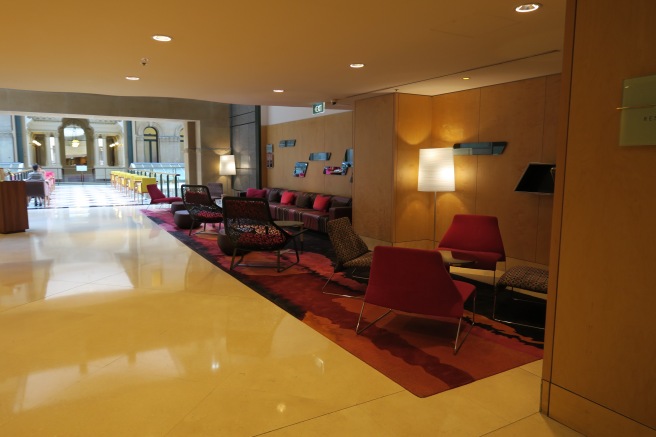 a room with a red and black rug and chairs