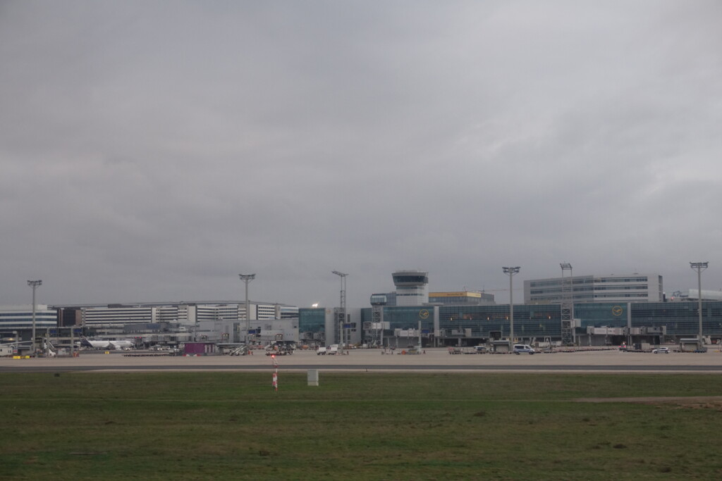 a field with buildings and a building in the background