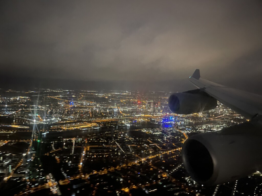 an airplane wing and lights in the sky