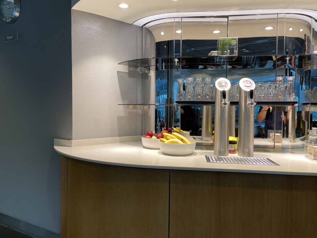 a counter with a glass shelf and a bowl of fruit