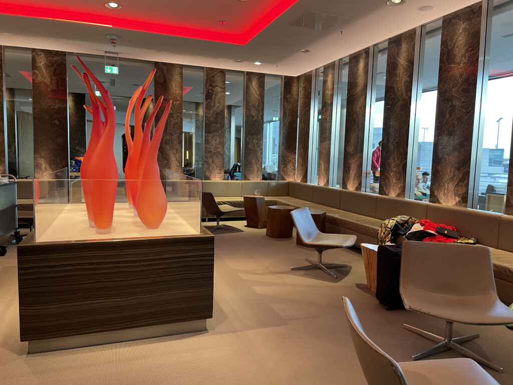 a room with a glass display case and chairs