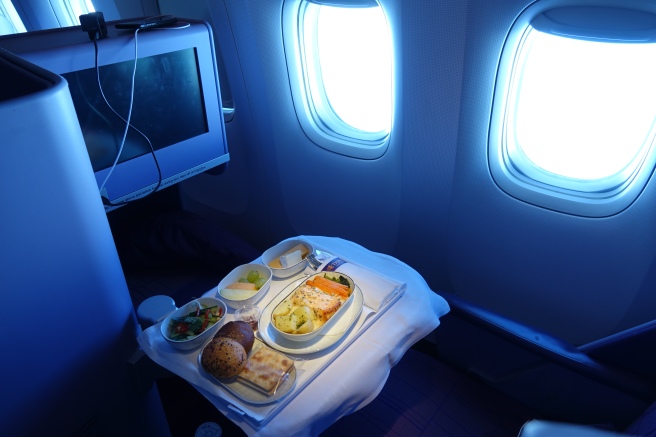 a tray of food on a table in an airplane