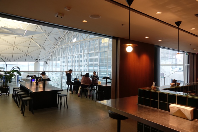 people sitting at tables in a room with windows