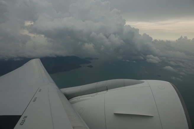 an airplane wing and clouds above water