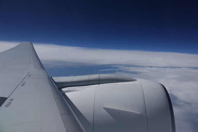 an airplane wing and blue sky