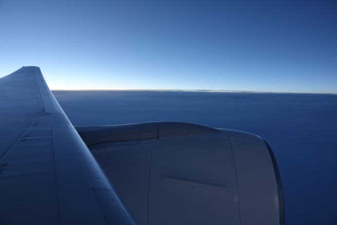 an airplane wing and blue sky