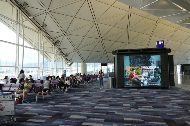 people sitting in a large room with a large screen