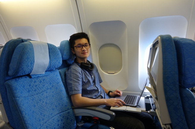 a man sitting on an airplane with a laptop