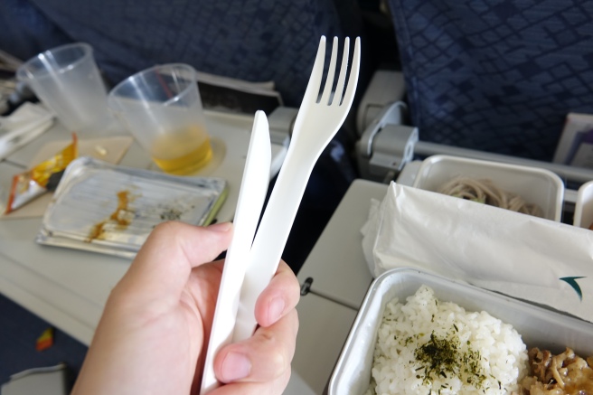 a hand holding a fork and a bowl of rice