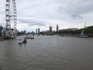 a river with boats and a ferris wheel