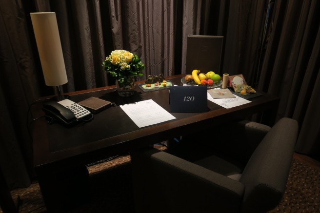 a desk with a phone and fruit on it