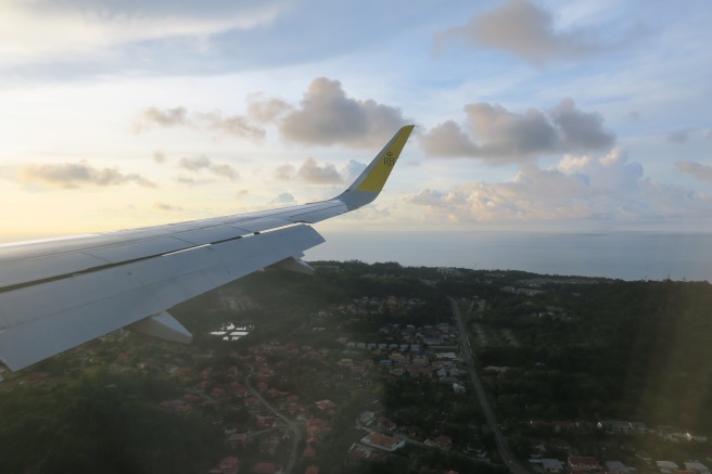 an airplane wing with a city and water in the background