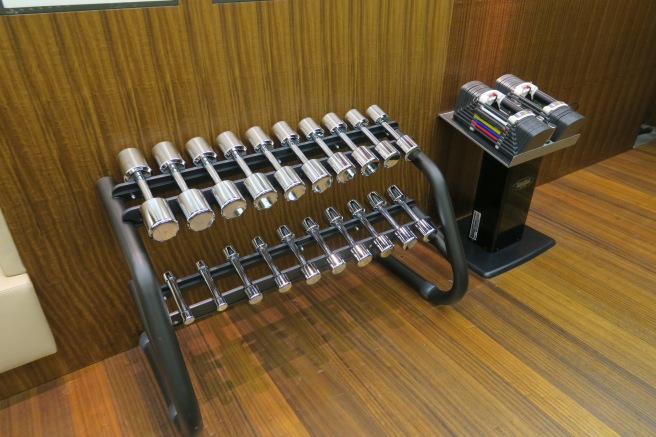 a rack of dumbbells on a wood floor