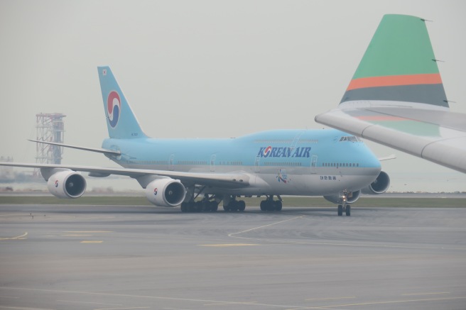 a blue airplane on a runway