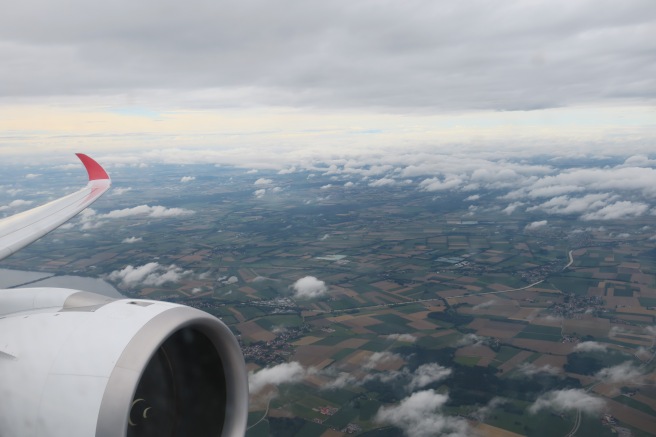 an airplane wing with clouds in the sky