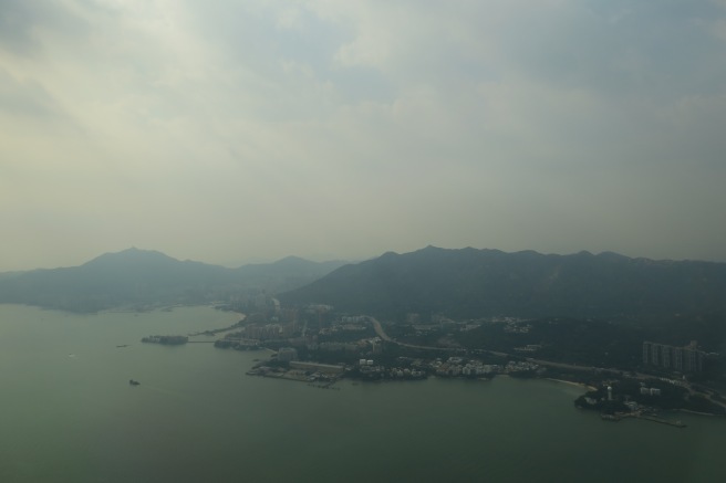 a body of water with buildings and mountains in the background